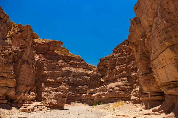 Mjuk fokus öken sand sten kanjon stenar passage spår mellan väggar förutser hortening underifrån på levande blå himmel bakgrund — Stockfoto