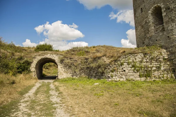 Castle wall fortress construction building stone wall arch shape passage ground dirt trail and vivid blue sky background clear weather day time — Stock Photo, Image