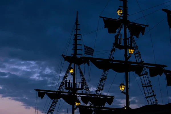 Vintage ship mast silhouettes with yellow illumination of lamps on evening twilight blue sky background — Stock Photo, Image