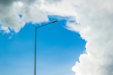 street outdoor high lantern lamp on iron pillar infrastructure object wallpaper pattern concept on empty blue sky background, copy space