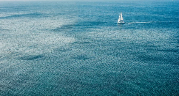 Summer vacation and expensive rest concept of small white yacht in Mediterranean sea, water surface with many waves, blue color, empty copy space for text — Stok fotoğraf