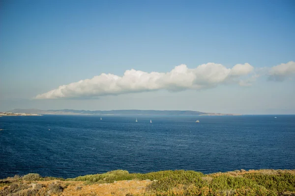 Vivid sea blue water scenic landscape and opposite coast line in fog on blue sky background with cloud, picturesque wallpaper pattern for poster or banner — Stockfoto