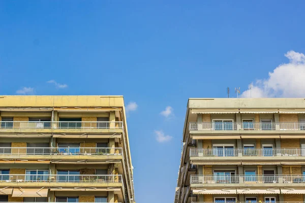 Condominio comune simmetria facciata frontale con balcone e finestre su sfondo cielo azzurro chiaro — Foto Stock