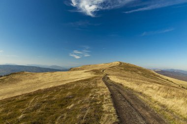 idyllic highland plateau dirt trail route along range autumn dry ground grass land and horizon background blue sky space