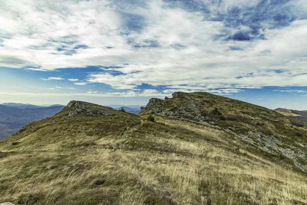 Terreno montañoso moody montaña rocosa paisaje hierba seca suelo y cielo azul nublado fondo vista panorámica — Foto de Stock