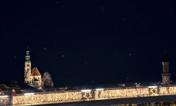 Ночной европейский город Зальцбург ориентир долгосрочной экспозиции фотографии городской вид с нечетким мостом желтые лампы освещения и здание церкви темно-звездный фон — стоковое фото
