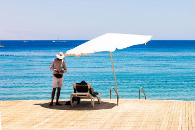 Sahil Oteli, rıhtım, ahşap güverte, Kızıl Deniz, sahil, şezlonga ve servis elemanı.