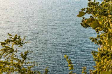 Basit doğa manzarası konsepti sabah vakti sakin su rezervuarı dalgalanma yüzeyi ve yaprak çerçeve önplanı metin için boş kopya alanı