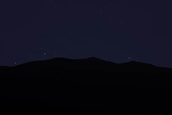 Night abstract long exposure landscape of black mountain silhouette shape on star sky background view in Carpathian Mountains — Stock Photo, Image
