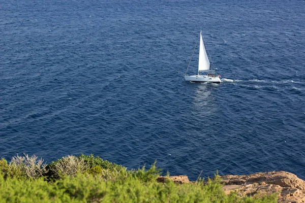 Повітряний пейзаж південного моря яскраво-синя вода поверхня і невелика біла одиночна яхта далеко від місця пострілу, туризму та літніх канікул концепція, копіювання простору — стокове фото