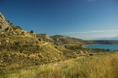 Kuru yaz mevsiminde boş kavisli eski araba yolu. Dağlık arazi. Çevre manzarası.