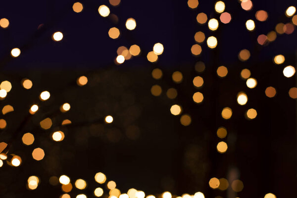 holidays festive unfocused golden illumination garland lamp in dark space background concept picture