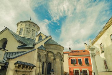 Lviv Ukrayna 'nın eski caddesi şehir simgesi binalar ön cephede ve kilise öncülüğünde aşağıdan canlı mavi gökyüzü beyaz bulutlar arka planda metin için boşluk