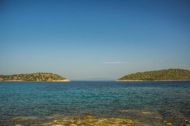 Huzurlu iki ada kıyı şeridi manzaralı manzara manzarası Ege Denizi Doğu Yunanistan kıyısı bölge bölgesi rahat lagün suları önplan ve metinleriniz için açık gökyüzü arkaplan alanı