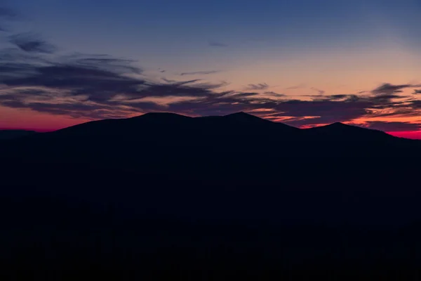 twilight mountain silhouette nature landscape abstract shape scenic view sunset evening time with orange purple and phantom blue color cloudy sky