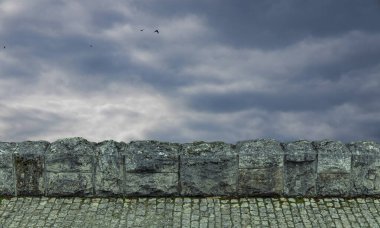 Asfaltlı yol taşı ön plan nesnesi karamsar dramatik bulutlu gökyüzü arkaplan manzaralı uçan kuşlar için duvar kağıdı arka plan alanı kopya veya metniniz için buraya
