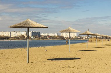 Ukrayna 'nın küçük şehri Khmelnytskyi' nin kırsal manzaralı deniz şemsiyeleri ortak gündüz vakti ve kameradan uzakta yalnız yürüyen insan.