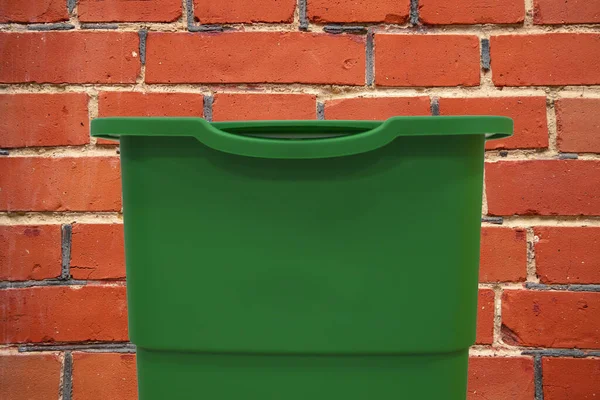 plastic trash can green object for cleaning with empty space for copy or your text here on brick wall background textured surface