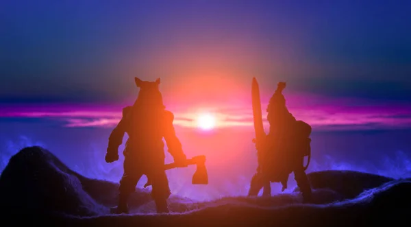 fantasy battle barbarian warriors silhouette in mountains highland hills in smoke on vivid colorful sunset light with orange pink sun glare and phantom blue sky background, toy shop concept picture