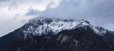 yumuşak odaklı karamsar dağ zirvesi Alp dağları panoramik manzara kış zamanı gri gökyüzü arka planı sisli