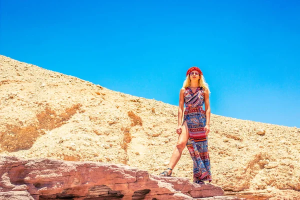 セクシーな可愛い女の子のポートレートでファッションドレス下から見て支配的な光景で砂漠明るい鮮やかなカラフルな自然温暖化環境青い空背景スペース — ストック写真