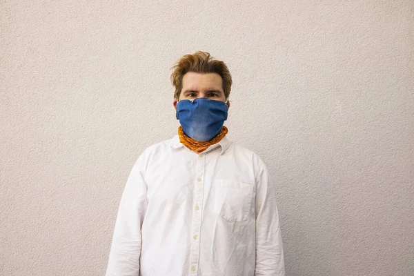 man in hand made jeans mask on face corona virus hard times quarantine conditions portrait on simple background wall space for copy or your text
