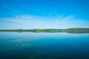 Huzurlu su yüzeyi önü ve ufuk kıyı şeridi manzarası sakin yaz günü fotokopi uzayı manzarası