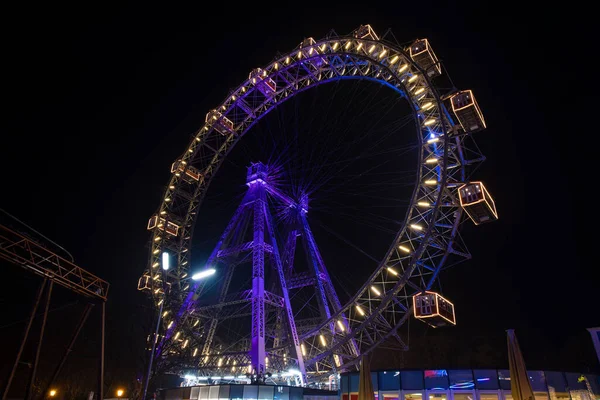 Ferris wheel carnival carousel night long exposure photography at night with blue purple and yellow illumination light