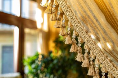 Dekor elementleri iç oda alanını ve pencere çerçevesi ve sıcak güneş ışığıyla odaklanmamış arkaplan görünümünü kapatır