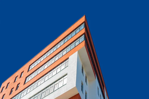 現代建築の建物三角形のファサード赤と白の色の前に鮮やかな青空の下から短縮シンプルな背景空のコピースペースあなたのテキストのためのポスター写真 — ストック写真