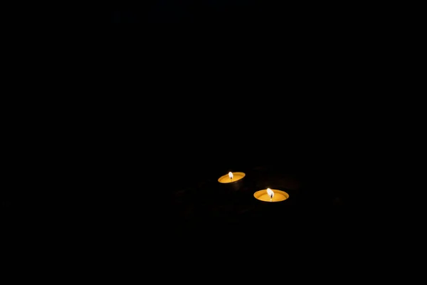 宗教精神沉默的气氛两支蜡烛在黑暗的火中熊熊燃烧在黑色的背景环境中 为你的复制或文本在此提供空间 — 图库照片