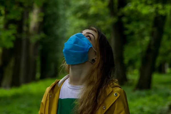 戴面具的年轻女子仰视着大自然 在森林里享受着新鲜的空气空间环境 与日冕病毒全球大流行病隔离的时间 — 图库照片
