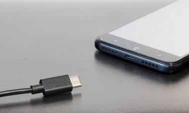 Telefon tarzı siyah aletler için USB şarj edici tarafsız karanlık arkaplan masa yüzeyi üzerinde nesneler metin için boş kopya alanı ile