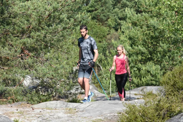 Mladý pár, praktikující nordic walkingu — Stock fotografie