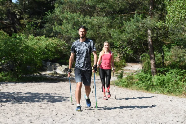 Młoda para, uprawiania nordic walkingu — Zdjęcie stockowe