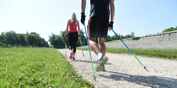 Młoda para, uprawiania nordic walkingu — Zdjęcie stockowe