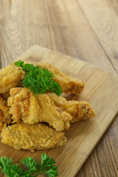 Fried Chicken,Crispy fried chicken wings on wooden plate,Parsley