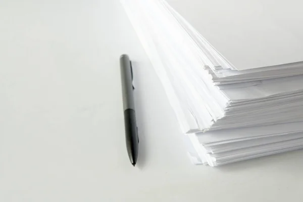 blank papers and black pen on white table,blank stack documents paper on office desk.