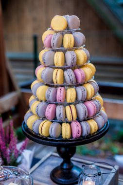Piramit şeklindeki plastik kule üzerinde renkli macarons şeker çubuğu tatlı tablonun bir parçası stand