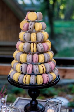 Piramit şeklindeki plastik kule üzerinde renkli macarons şeker çubuğu tatlı tablonun bir parçası stand