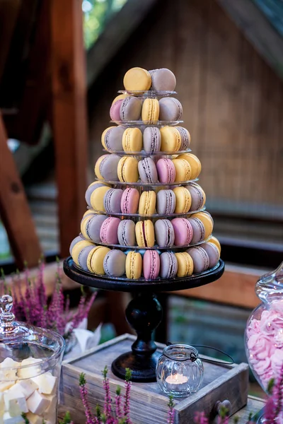 Barevné macarons na plastové věž ve tvaru pyramidy stojí jako součást candy bar sladké tabulky — Stock fotografie
