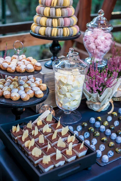 Chocolate feito à mão bombons doces em um prato de ardósia preta como parte da barra de doces mesa doce. Decoração de outono. Luz natural — Fotografia de Stock