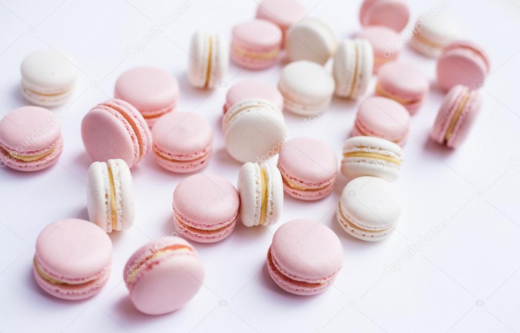 Tender pink and white macarons on white background. Natural light. Selective focus