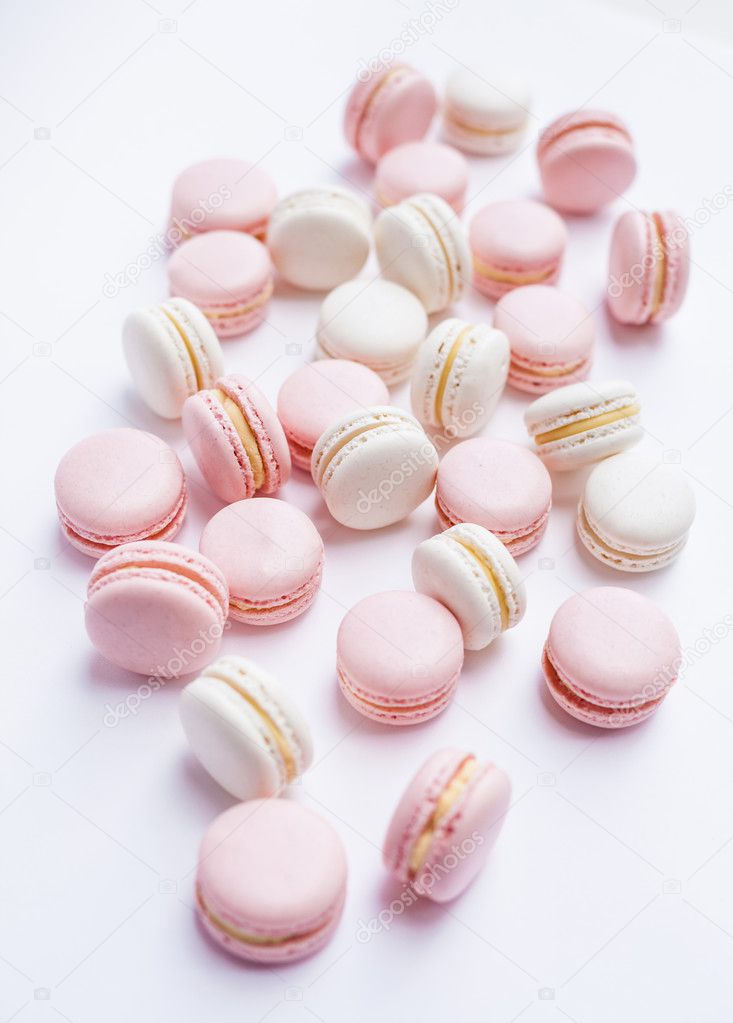 Tender pink and white macarons on white background. Natural light. Selective focus