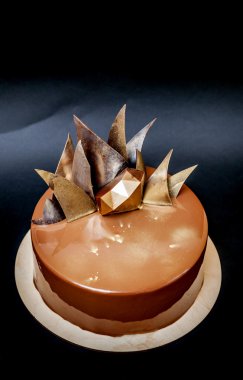 Trendy modern çikolatalı mousse kek ayna sır ve çikolata dekor ile dekore edilmiştir. Siyah arka plan.