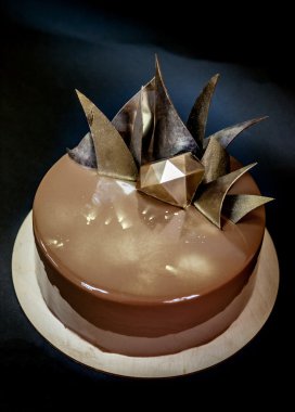 Trendy modern çikolatalı mousse kek ayna sır ve çikolata dekor ile dekore edilmiştir. Siyah arka plan.
