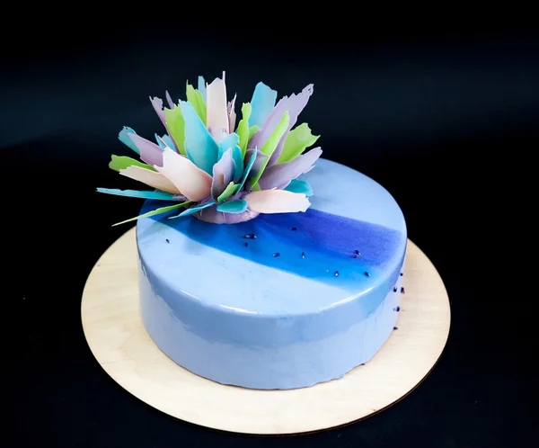 Сучасний модний торт з блакитно-фіолетовою дзеркальною глазур'ю та шоколадним квітковим декором. Чорний фон . — стокове фото