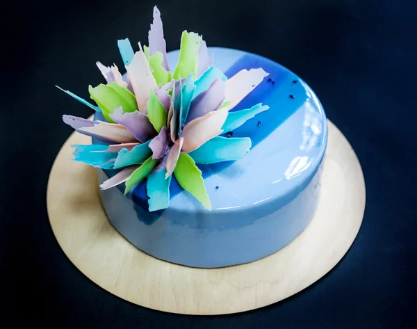 Moderní trendy dort s modrých a fialových mirror poleva a čokoládová květinová výzdoba. Černé pozadí. — Stock fotografie