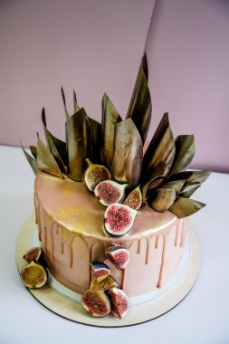 Modaya uygun modern çikolata karamel katmanlı kek çikolata sır, incir ve çikolata dekor ile dekore edilmiş.