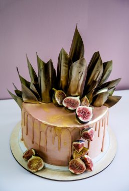 Modaya uygun modern çikolata karamel katmanlı kek çikolata sır, incir ve çikolata dekor ile dekore edilmiş.